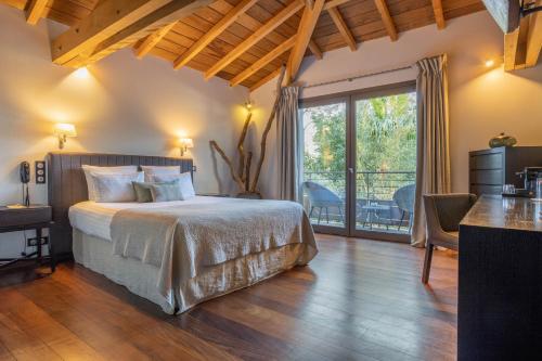a bedroom with a large bed and a balcony at Hôtel Côté Sable in Cap-Ferret