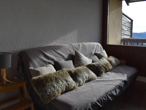 豐羅默奧代洛維亞的住宿－Appartement Font-Romeu-Odeillo-Via, 2 pièces, 4 personnes - FR-1-580-11，靠窗坐在一张铺着毛皮的沙发上