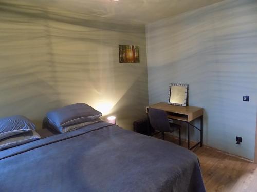a bedroom with a bed and a desk with a laptop at La'Vista in Smolyan