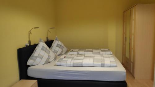 a bed in a room with two pillows on it at Ferienwohnung Zöllner in Burg