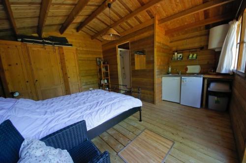 ein Schlafzimmer mit einem großen Bett in einer Holzhütte in der Unterkunft Domaine La faix, Gite le Verger in Saint-Plaisir