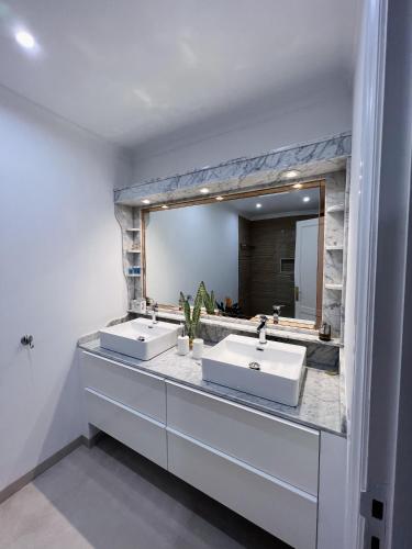 a bathroom with two sinks and a large mirror at Casa Cielo in Arrecife