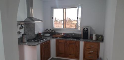 una cocina con fregadero y una ventana. en Beach Houses, en Sfax