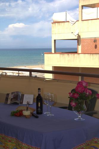 a table with a bottle of wine and two glasses at Residence Mediterraneo in Marina di Grosseto