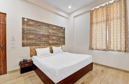 una camera da letto con un grande letto bianco e una finestra di Hotel Amrapali Inn Jaipur a Jaipur
