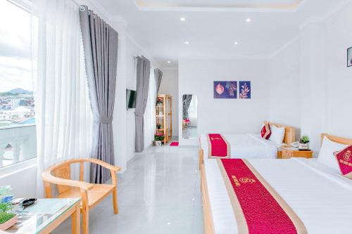 a white room with a bed and a desk and a table at Ngọc Sang 3 Hotel in Da Thanh