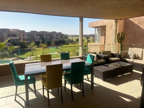 a living room with a table and chairs and a couch at Appartement golf prestigia in Marrakesh