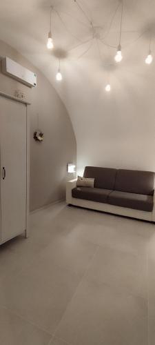 a living room with a couch in a white room at Itinerario Barocco Apartment Ragusa Ibla - Eleganza e Comfort nel Cuore del Barocco Siciliano in Ragusa
