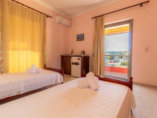 a hotel room with two beds and a window at PORTO-FINO in Arillas