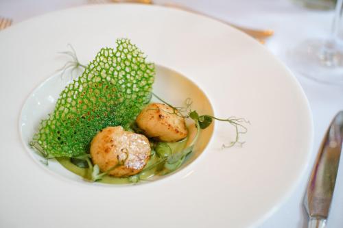 a bowl of food with broccoli and potatoes on a table at Berwick Lodge in Bristol