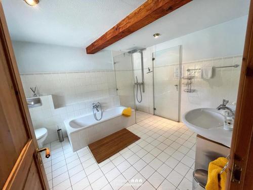 een badkamer met een douche, een bad en een wastafel bij Reetdach-Oase in Brarupholz