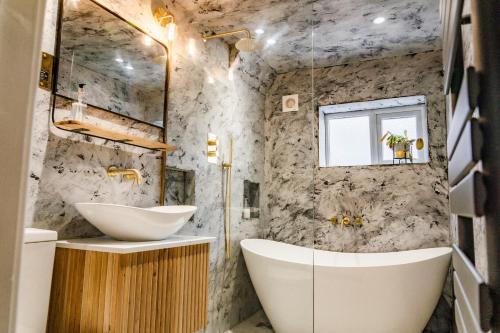 a bathroom with two sinks and a tub at Benyon Street Townhouse in Shrewsbury