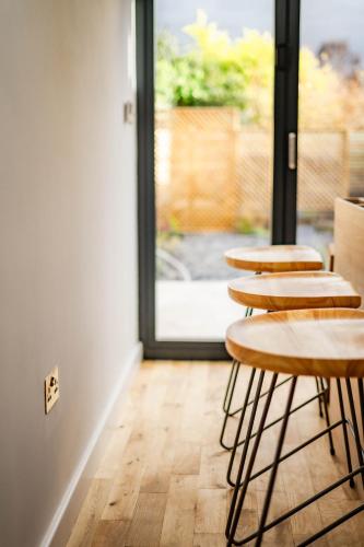 a row of tables in a room with a window at Benyon Street Townhouse in Shrewsbury