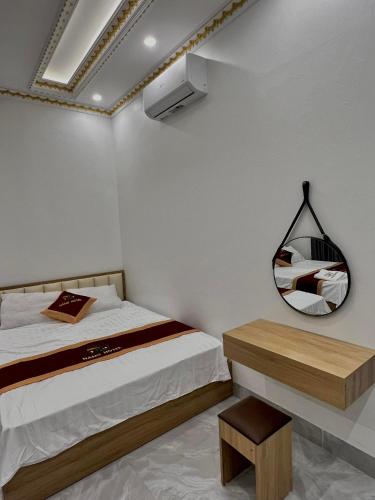 NẮNG HOTEL في Mù Cang Chải: غرفة نوم بسرير ومرآة وطاولة