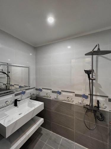 NẮNG HOTEL في Mù Cang Chải: حمام مع حوض أبيض ومرآة