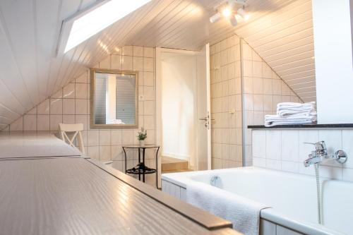 a bathroom with a tub and a sink at Ferienwohnungen Domblick-Herkenrath in Bergisch Gladbach