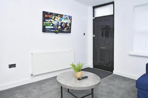 a living room with a table and a black door at Townhouse @ 20 Penkhull New Road Stoke in Stoke on Trent