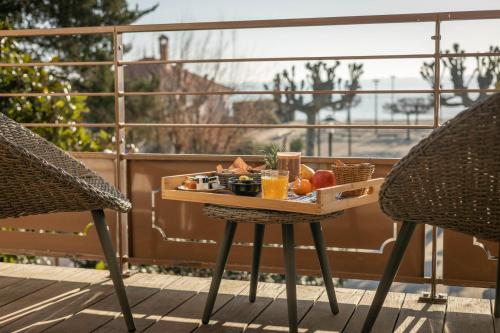 a tray of food on a table on a balcony at Hôtel Côté Sable in Cap-Ferret