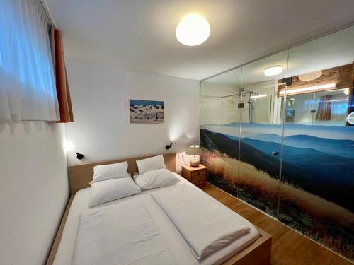 Schlafzimmer mit einem Bett mit Wandgemälde in der Unterkunft Appartement Germann in Neukirchen am Großvenediger