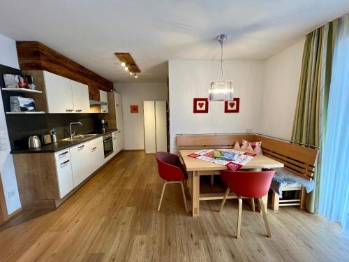 eine Küche und ein Esszimmer mit einem Tisch und Stühlen in der Unterkunft Appartement Germann in Neukirchen am Großvenediger