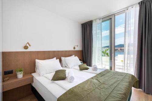 een slaapkamer met een groot bed en een groot raam bij Luxury & stylish Villa Maslina 10 m from the sea in Vela Luka