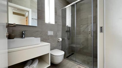 een badkamer met een douche, een toilet en een wastafel bij Luxury & stylish Villa Maslina 10 m from the sea in Vela Luka