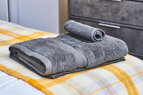 uma pilha de toalhas sentadas em cima de uma cama em 5 minutes from Leeds City Centre - Parking em Leeds