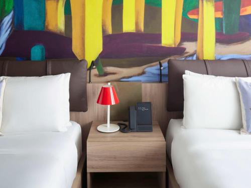 ein Schlafzimmer mit 2 Betten und einem Tisch mit einer Lampe in der Unterkunft Mondrian Mexico City Condesa in Mexiko-Stadt