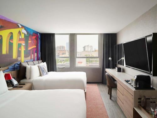 a hotel room with two beds and a flat screen tv at Mondrian Mexico City Condesa in Mexico City