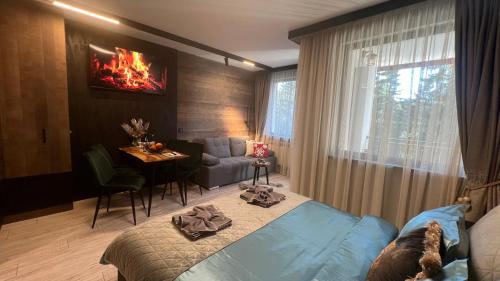 a bedroom with a bed and a living room at Апартамент - Боровец Хотел ''Боровец Гардънс'' A 44 in Borovets