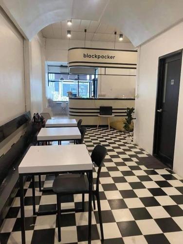 a room with tables and chairs on a checkered floor at Matcha House jomtien Pattaya in Jomtien Beach