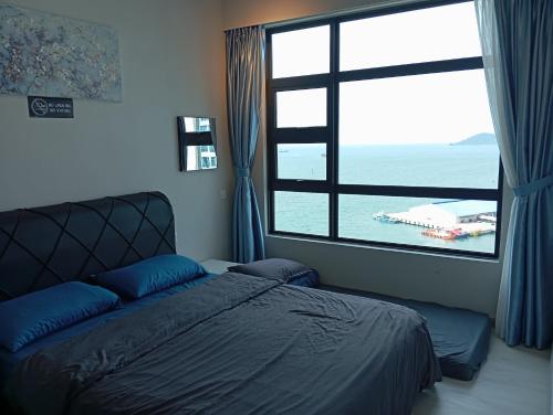 a bedroom with a bed and a large window at LW Suite at JQ Seaview 2BR High Floor & Wi-Fi in Kota Kinabalu