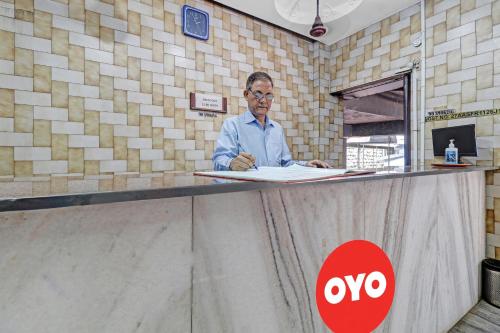 a man sitting at a counter with a paper at Hotel Rajdoot Near Phoenix Palladium in Mumbai