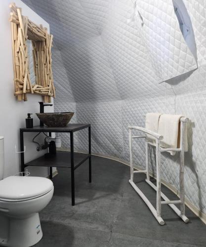 a bathroom with a toilet and a table and a sink at River Glamping Kalopanayiotis in Kalopanayiotis