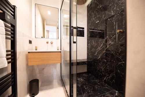 uma casa de banho com um chuveiro e um lavatório. em CIA - Opera em Paris