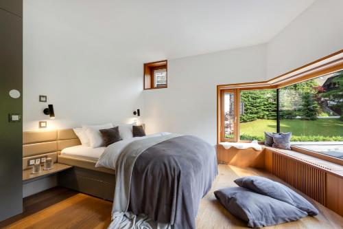 ein Schlafzimmer mit einem Bett und einem großen Fenster in der Unterkunft Jasna Mansion in Kranjska Gora