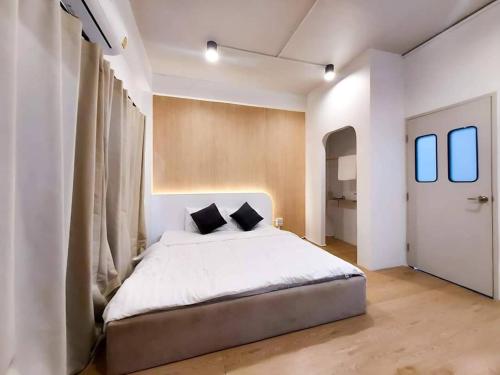 Matcha House jomtien Pattaya في جومتين بيتش: غرفة نوم مع سرير أبيض كبير مع وسائد سوداء