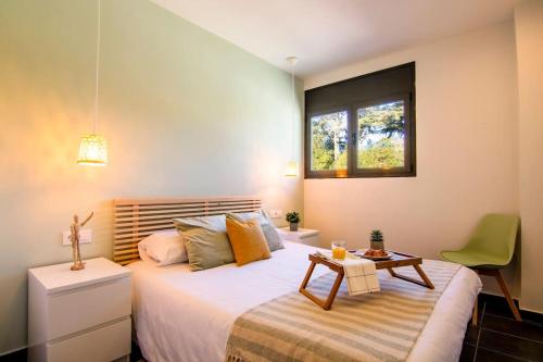 um quarto com uma cama com uma mesa e uma janela em SeaHomes Vacations - ACACIAS Beach&Chic em Lloret de Mar