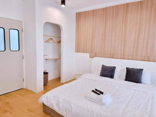 a white bedroom with a large white bed with a tray on it at Matcha House jomtien Pattaya in Jomtien Beach