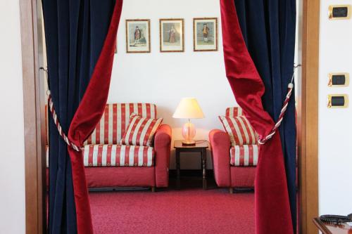 a living room with two chairs and a curtain at Termini Beach Hotel & Suites in Lido di Jesolo
