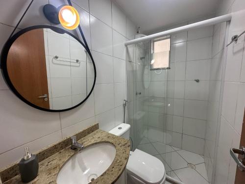 a bathroom with a sink and a mirror and a toilet at Mirante Cidade in Vitória da Conquista