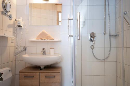 a bathroom with a sink and a shower at Hotel Restaurant Amadeus in Bad Hindelang