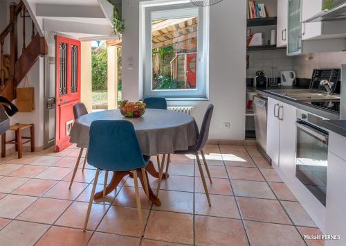 - une cuisine avec une table et des chaises dans la chambre dans l'établissement RÉF 398 - HENNEBONT maison de ville de caractère avec jardinet et patio, à Hennebont