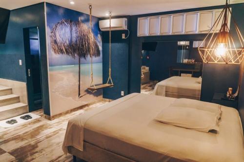 een slaapkamer met 2 bedden en een badkamer bij Motel Champagne by Drops in Tubarão