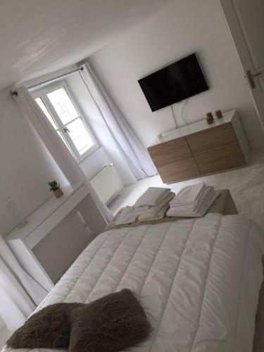 une chambre avec un lit blanc et une télévision dans l'établissement APPARTEMENT AU COEUR DU PARIS TOURISTIQUE, à Paris