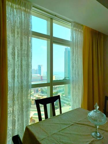 a dining room with a table and a large window at Sea View - 2BHK - Al Reem Island 6ppl Free Transportation from AD Airport in Abu Dhabi