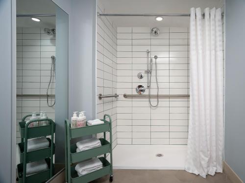 ein Badezimmer mit einer Dusche und einem grünen Regal in der Unterkunft The Wayback, Pigeon Forge, A Tribute Portfolio Hotel in Pigeon Forge