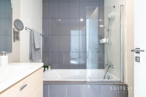 Experience Comfort in Our Charming 3-Bedroom Villa في دبي: حمام مع دش وحوض استحمام أبيض