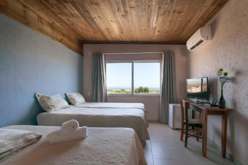 um quarto de hotel com duas camas e uma janela em Pousada Moquirido em Florianópolis