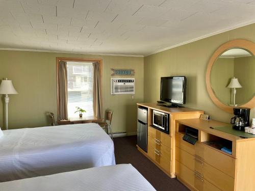 a hotel room with a bed and a television at Moontide Motel, Apartments, and Cabins in Old Orchard Beach